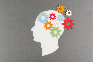 top view of cut out white human head with colorful gears isolated on grey