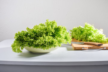 Green fresh lettuce leaves on the kitchen table.