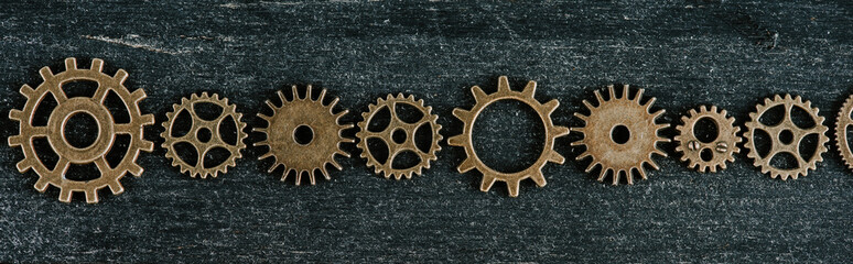 Sticker - flat lay with vintage metal gears on dark wooden background, panoramic shot