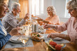 © Drazen - Cheerful mature couple enjoying in lunch with their friends at home.