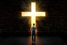 A Man Walking Towards A Glowing Cross