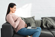 © LIGHTFIELD STUDIOS - happy pregnant woman having online consultation with doctor on laptop at home