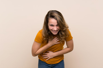 Wall Mural - Young blonde girl over isolated background smiling a lot