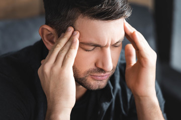 Wall Mural - handsome man with headache touching head in apartment