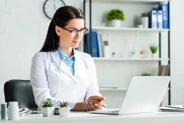 confident doctor having online consultation with patient on laptop in clinic office