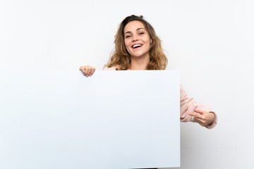 Wall Mural - Young blonde woman holding an empty white placard for insert a concept