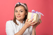 © LIGHTFIELD STUDIOS - attractive and smiling woman holding gift isolated on pink