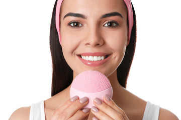 Poster - Young woman using facial cleansing brush on white background, closeup. Washing accessory