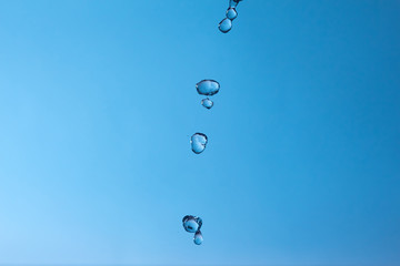 Wall Mural - Falling water drops on a blue background.