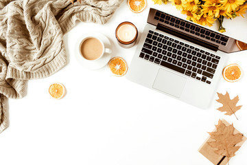 Wall Mural - Home office table desk workspace with laptop decorated with yellow daisy flowers bouquet, coffee cup, orange slices, plaid. Flat lay, top view freelance business concept for social media, magazine.