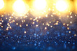 © fotomaximum - Christmas vintage lights background. Gold lights and blue glitter. defocused