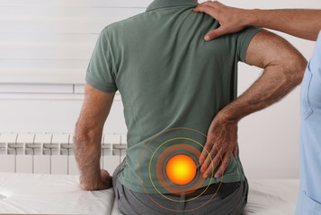 Wall Mural - Senior man with back pain. Spine physical therapist and paient. Chiropractic pain relief therapy.