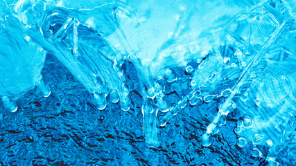 Blue ice and blue bubbling water. A variety of ice patterns and shades of blue in glacial ice and water.Background image for spa salon. Flat lay .Copy-Space