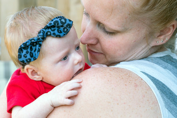 Mother Holding Happy Baby with Bright Blue Eyes