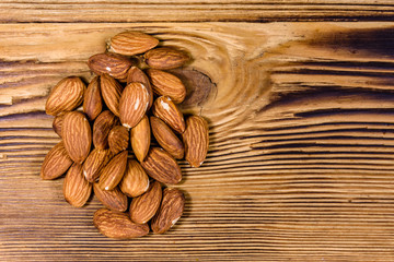 Heap of the peeled almond nuts on wooden table. Top view