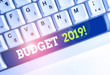 Conceptual hand writing showing Budget 2019. Concept meaning estimate of income and expenditure for current year White pc keyboard with note paper above the white background