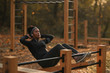 © Drazen - African American female athlete doing sit-ups at outdoor gym.