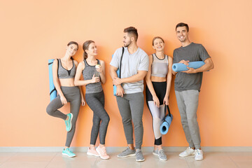 Poster - Group of people with yoga mats near color wall