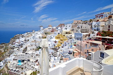 Oia town on Santorini island, Greece. Traditional and famous white houses and churches with blue domes over the Caldera, Aegean sea.