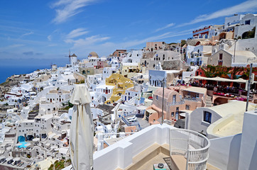 Oia town on Santorini island, Greece. Traditional and famous white houses and churches with blue domes over the Caldera, Aegean sea.