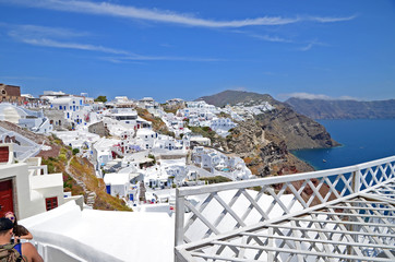 Oia town on Santorini island, Greece. Traditional and famous white houses and churches with blue domes over the Caldera, Aegean sea.