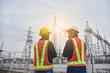 © Suriyo - Man and Women Engineering standing communication at power plant  electrical system background