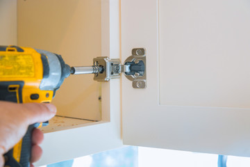 Mounting hinges for chipboard furniture assembling kitchen furniture. Place carpentry workshop.