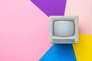 Vintage monitor with a kinescope on a multicolored background. Vintage electronics.