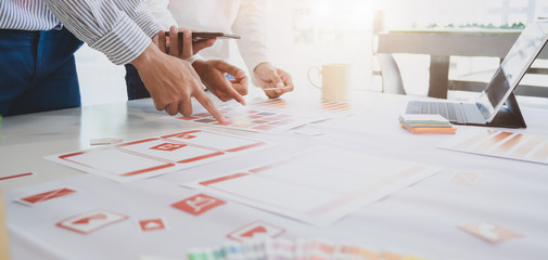 Close-up view of young professional UX web developer team working on smartphone template
