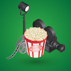 Canvas Print - 3D studio light with video camera, film reel and popcorn bucket on green background.