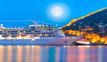 Wall Mural - Beautiful white giant luxury cruise ship on stay at Alanya harbor with full moon