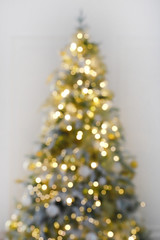 blur light celebration on christmas tree with white wall background. defocus holiday background.