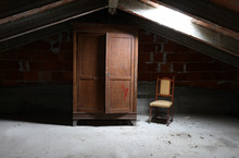 Old Wooden Wardrobe And A Vintage Chair In The Dusty Attic
