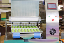 Making Sweet Cakes On A Production Line. A Baking Machine With A Conveyor On Which Confectionery Is Located. The Operation Of The Machine Is Shown. Molding System.