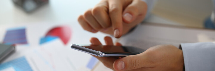 A businessman holds a new smartphone