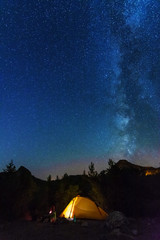 Wall Mural - vertical landscape images with a night starry sky and a milky way against the backdrop of a yellow t