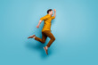 © deagreez - Full size profile side photo of cheerful positive man jump run after spring time sales wear casual style outfit sneakers isolated over blue color background