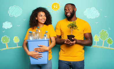 Wall Mural - Happy couple hold a plastic container with bottles and a small tree over a light blue color. Concept of ecology, conservation, recycling and sustainability