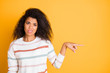 Closeup photo portrait of unhappy sad upset expressing disgust girl showing pointing finger to copy space isolated bright color background