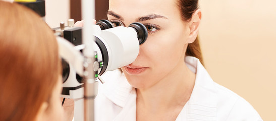 Wall Mural - ophthalmologist doctor in exam optician laboratory with female patient. Eye care medical diagnostic. Eyelid treatment