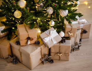 close up of beige gift boxes under decorated christmas tree