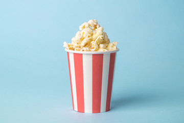 Popcorn in disposable box isolated on blue.