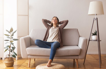 millennial girl relaxing at home on couch, enjoying free time
