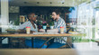 © BullRun - Multiethnic couple chatting with each other in coffee shop