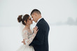 © Tetiana Moish - Beautifull wedding couple kissing and embracing. Winter wedding. People, season, love and leisure concept - happy couple hugging and laughing outdoors in winter.