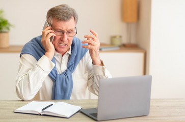 Wall Mural - Discontented Senior Man Talking On Phone Sitting In Modern Office