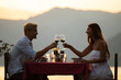 © NDABCREATIVITY - Couple sharing romantic sunset dinner on tropical resort