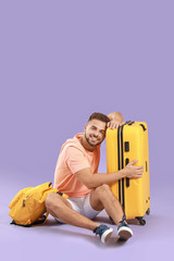 Poster - Young male tourist with luggage on color background