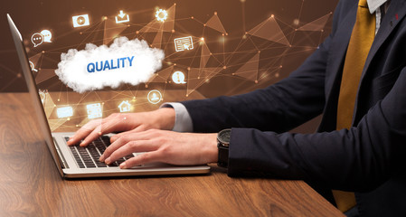 businessman working on laptop with quality inscription, modern technology concept