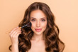 © deagreez - Close up photo of gorgeous glamorous wavy haired girl apply rouge powder hold brush want prepare for date be attractive use professional skin care products isolated over beige color background